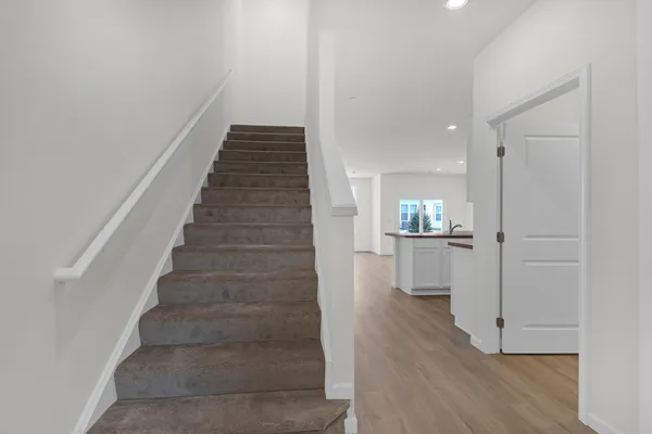 a view of a hallway with wooden floor and staircase