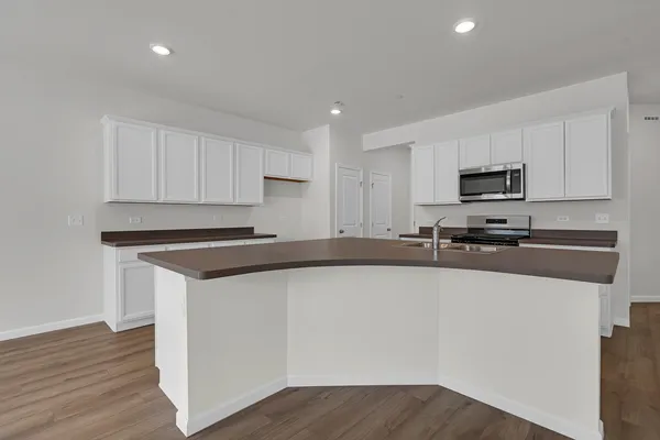 a kitchen with granite countertop a refrigerator and a stove top oven