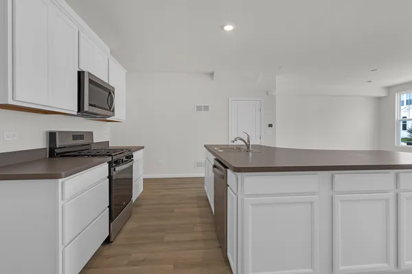 a kitchen with stainless steel appliances granite countertop a sink and a stove top oven