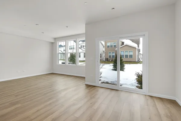 a view of a big room with wooden floor and door