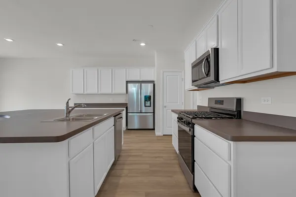 a kitchen with stainless steel appliances granite countertop a sink stove and refrigerator