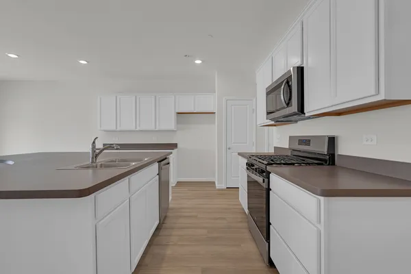 a kitchen with stainless steel appliances granite countertop a sink stove and cabinets