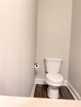 a white toilet sitting next to a white wall