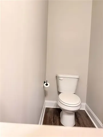 a white toilet sitting next to a white wall