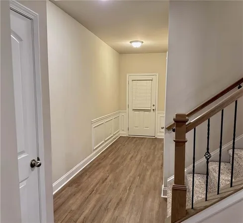 a view of a hallway with wooden floor and staircase