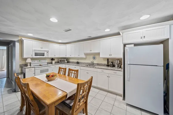 a kitchen with stainless steel appliances granite countertop a stove top oven a sink dishwasher and a refrigerator with the cabinets