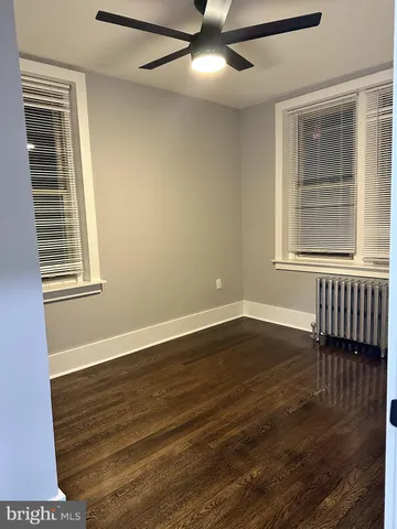 an empty room with wooden floor and closet area