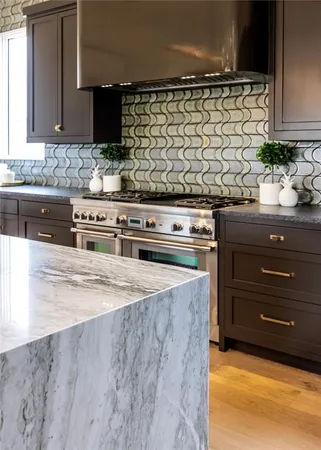 a kitchen with stainless steel appliances granite countertop a stove a sink and a microwave