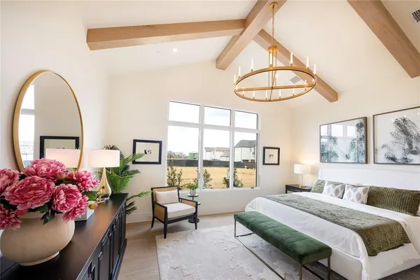 a bedroom with a bed a chandelier and a large window