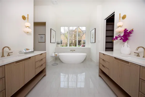 a spacious bathroom with a double vanity sink a mirror and a bathtub