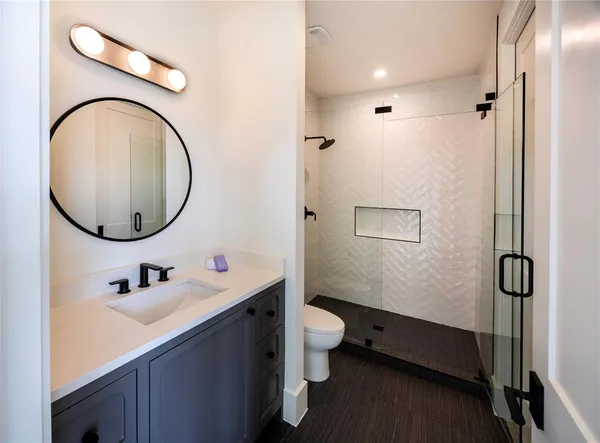a bathroom with a sink a toilet and a mirror