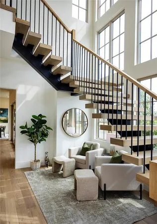 a living room with patio furniture and potted plants with wooden floor