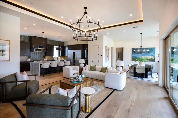 a living room with furniture kitchen view and a chandelier