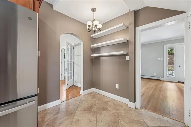 a view of a hallway with wooden floor and a chandelier