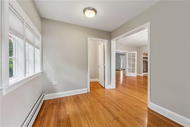a view of a room with wooden floor and a window