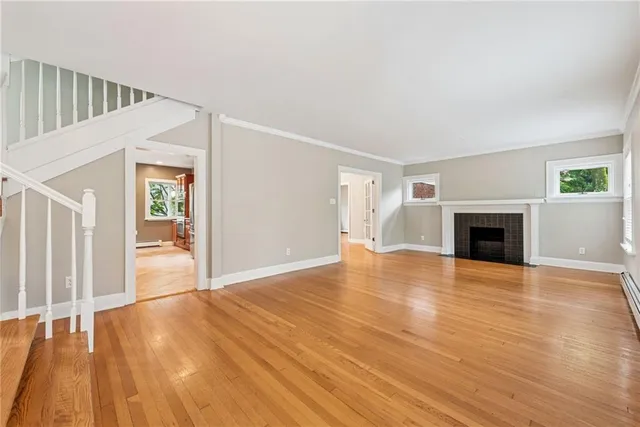 a view of empty room with wooden floor and fireplace