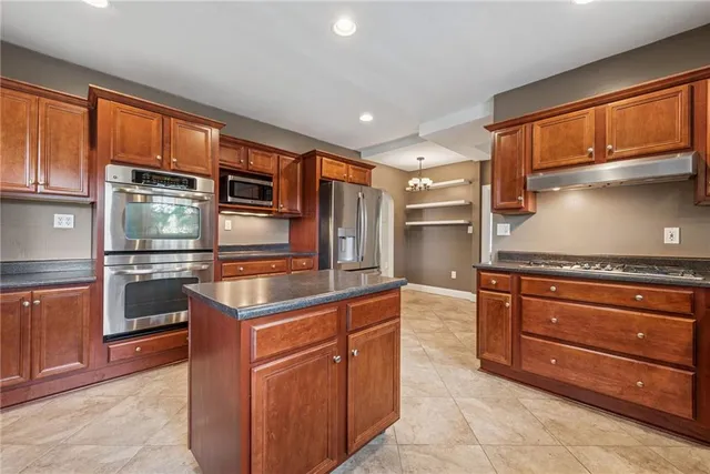 a kitchen with stainless steel appliances granite countertop a sink and cabinets