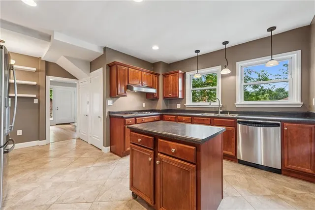 a kitchen with stainless steel appliances granite countertop a sink and a stove