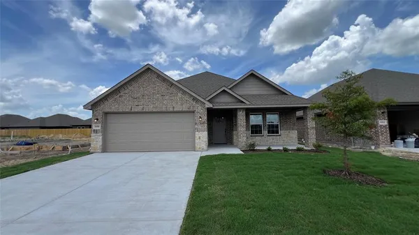 a front view of a house with a garden and yard