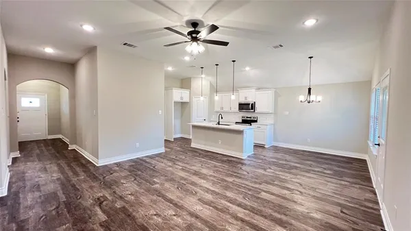 a kitchen with granite countertop a sink a counter top space stainless steel appliances and cabinets