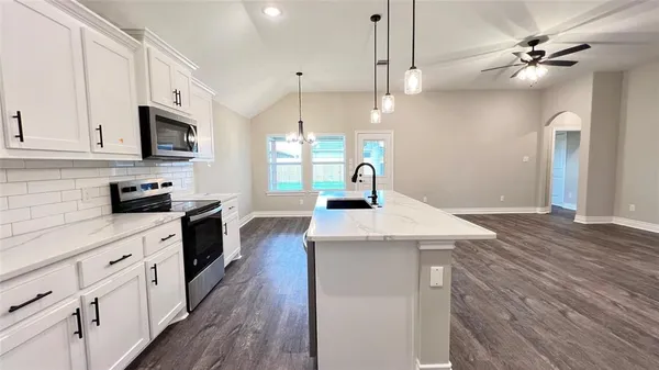 a kitchen with kitchen island a sink stainless steel appliances and window