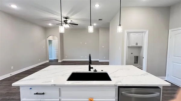 a large white kitchen with sink and white appliances