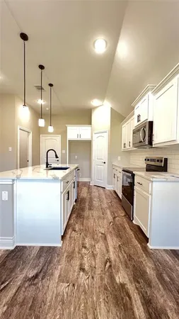 a kitchen with kitchen island a stove a counter top space and a fireplace