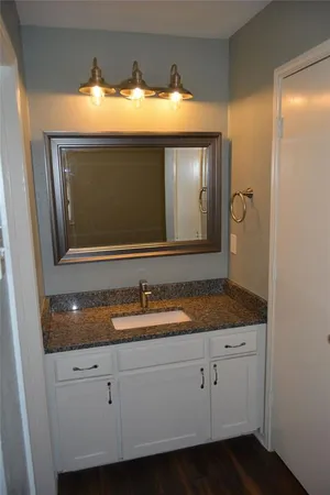 a bathroom with a granite countertop sink and mirror