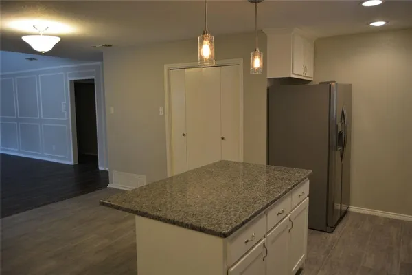 a kitchen with stainless steel appliances granite countertop cabinets and refrigerator