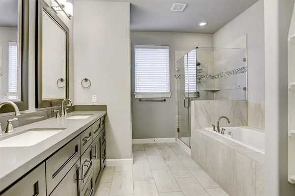 a spacious bathroom with a tub sink and mirror