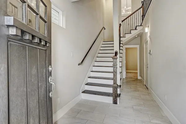 a view of staircase with lots of frames on wall and stairs