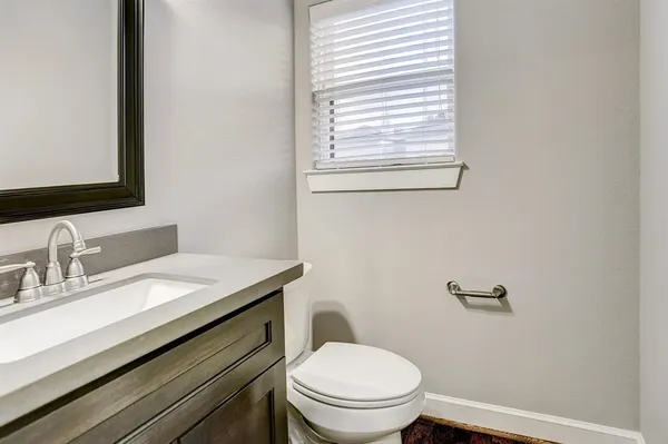 a bathroom with a granite countertop toilet sink and mirror
