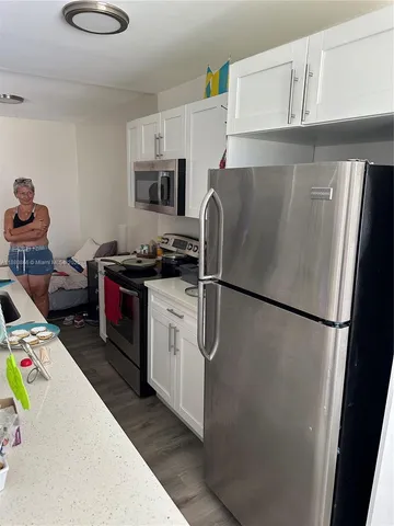 a kitchen with stainless steel appliances a refrigerator sink and cabinets