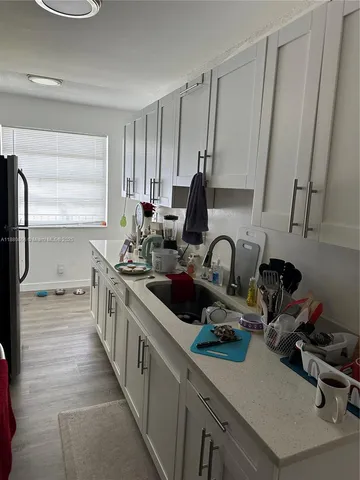 a kitchen with sink a refrigerator and cabinets