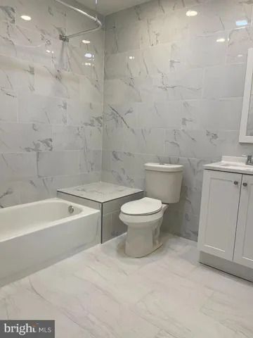 a white toilet sitting next to a bath tub
