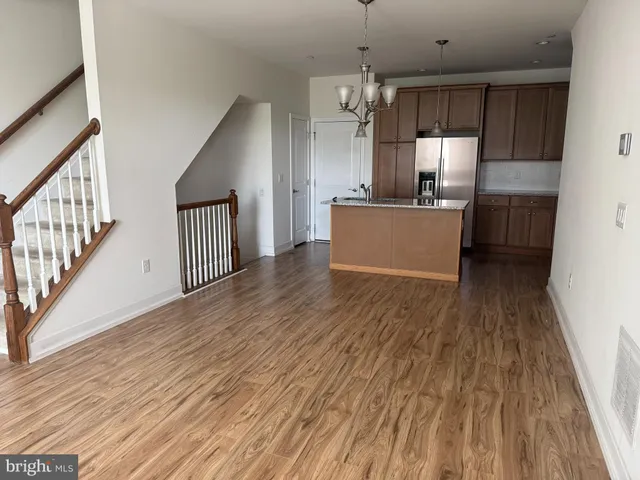 a view of a kitchen with wooden floor and stainless steel appliances