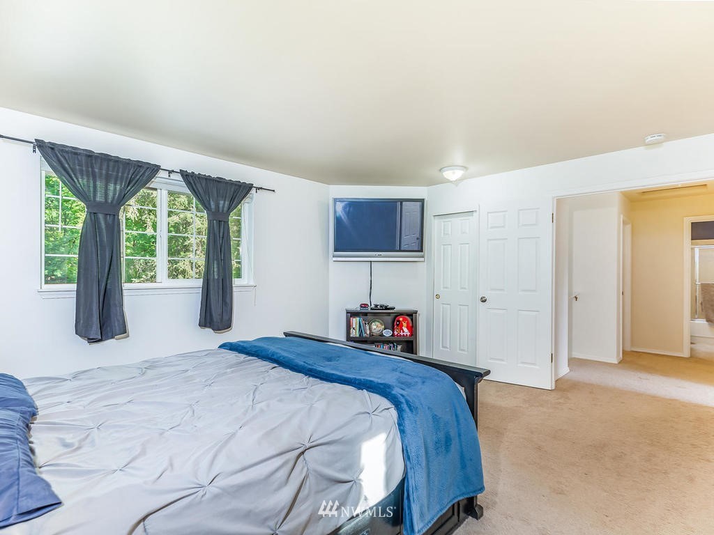 3220 228th Street Southeast Bothell, WA 98021 - Photo 17 of 35 a bedroom with a large bed and a large window