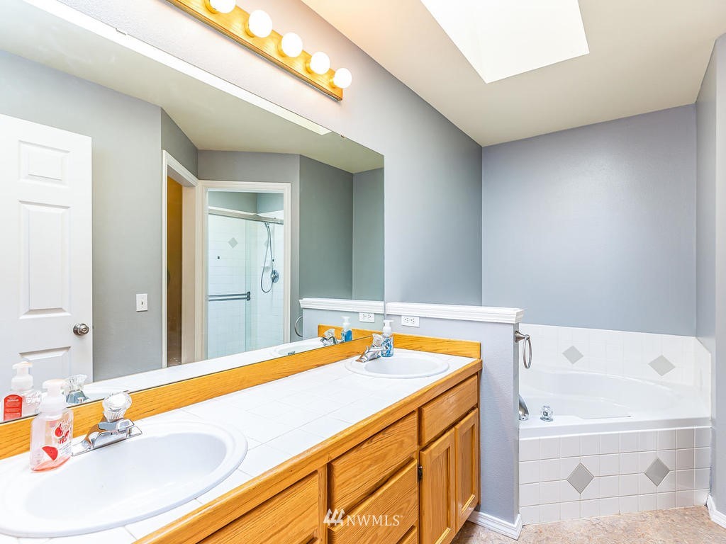 3220 228th Street Southeast Bothell, WA 98021 - Photo 18 of 35 a bathroom with a tub a sink and a large mirror