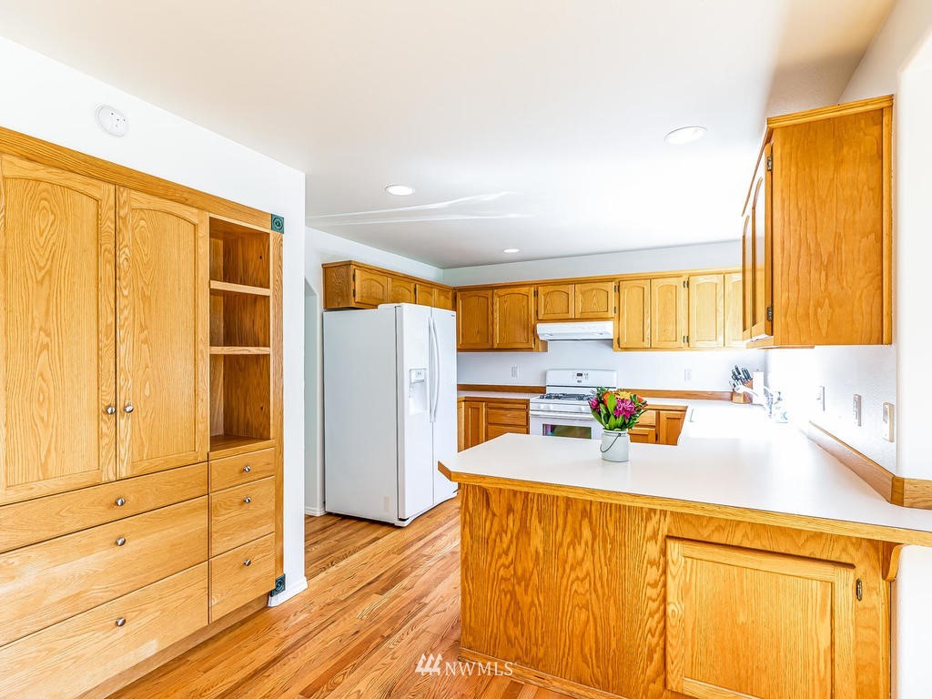 3220 228th Street Southeast Bothell, WA 98021 - Photo 7 of 35 a kitchen with stainless steel appliances granite countertop a sink refrigerator and cabinets