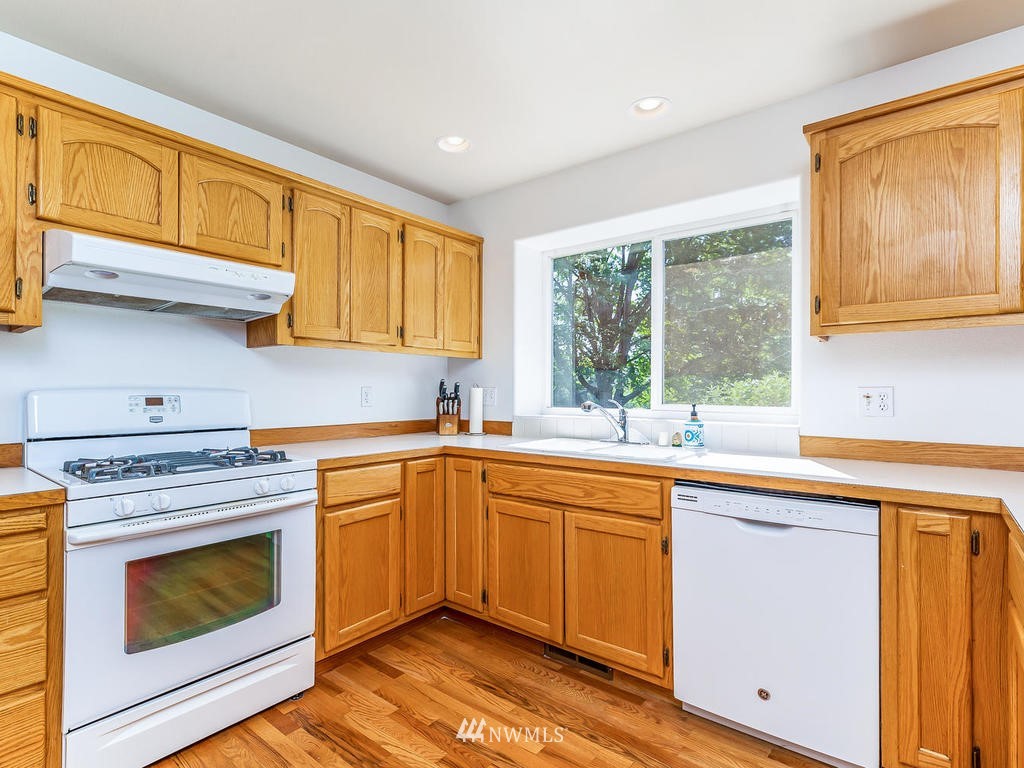 3220 228th Street Southeast Bothell, WA 98021 - Photo 8 of 35 a kitchen with a sink cabinets appliances and a window