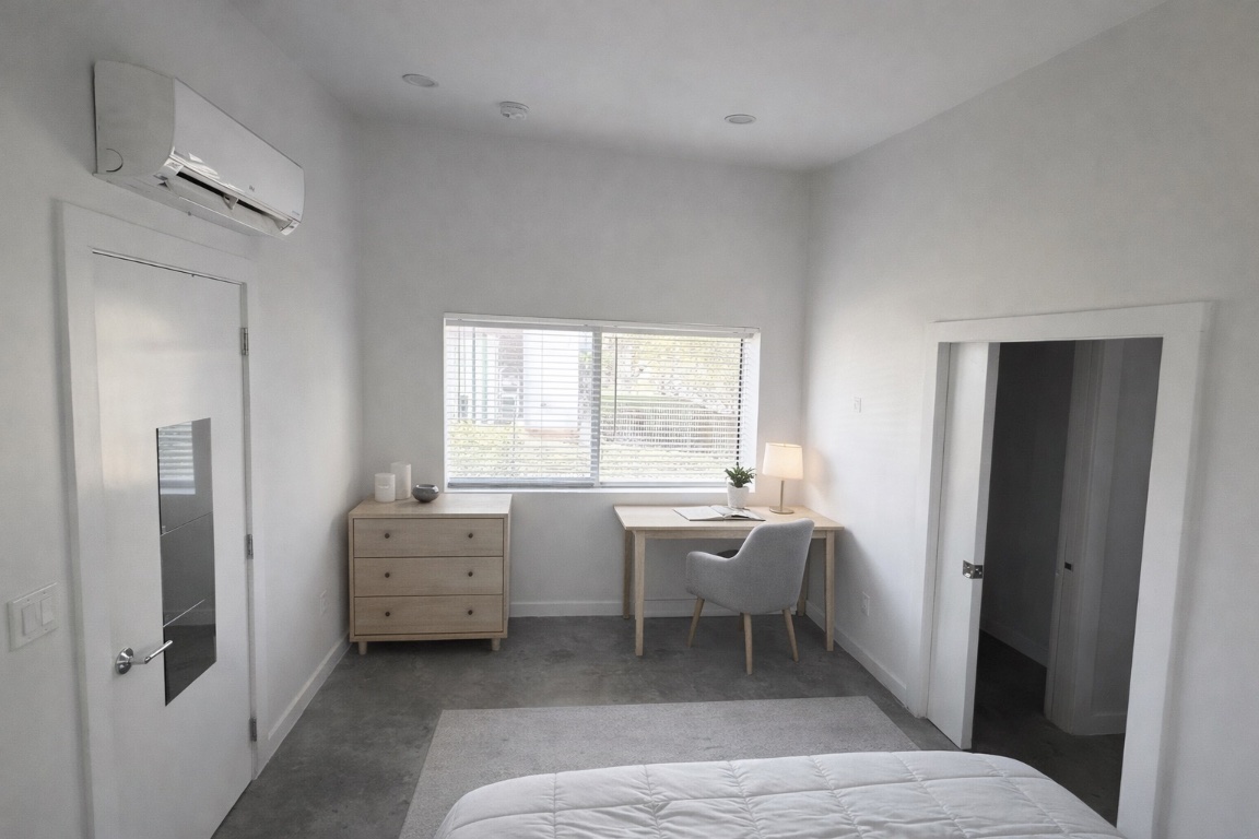 1155 Perry Road, Unit B Austin, TX 78721 - Photo 5 of 7 Carpeted bedroom featuring a wall mounted AC and an office area
