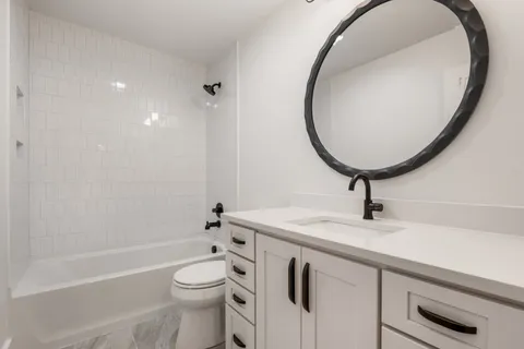 a bathroom with a sink a toilet and a mirror