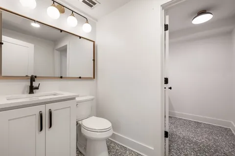 a bathroom with a toilet a sink and mirror