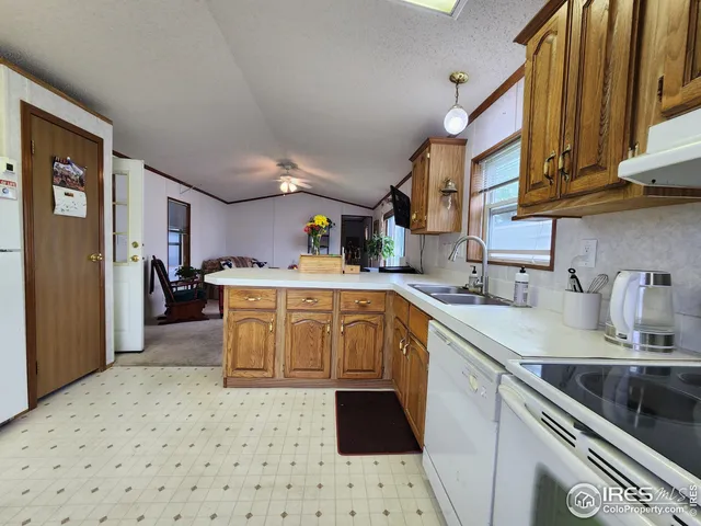 a kitchen with stainless steel appliances a sink a stove a refrigerator cabinets and a window