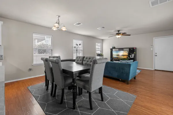 a living room with furniture kitchen view and a chandelier