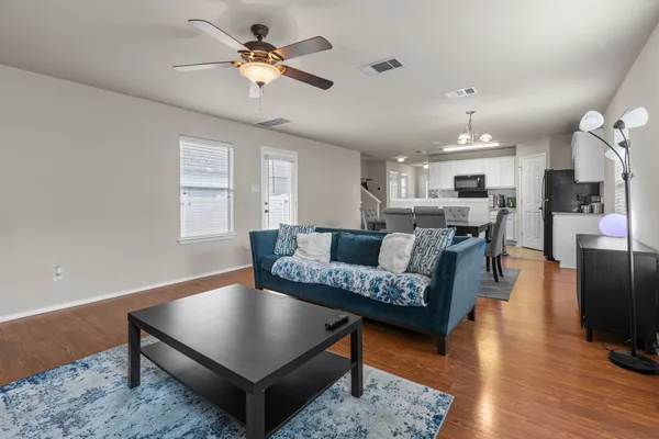 a living room with furniture and wooden floor