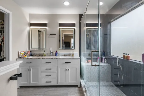 a bathroom with a granite countertop shower and a sink
