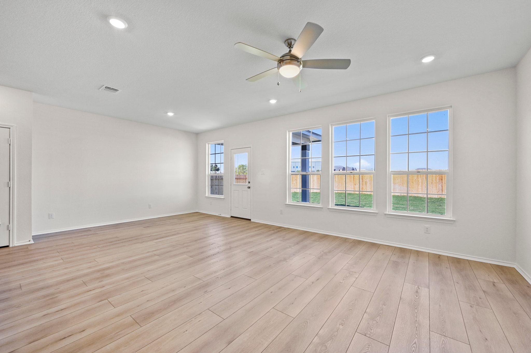 15004 Garrano Way Manor, TX 78653 - Photo 11 of 34 a view of an empty room with wooden floor and a window