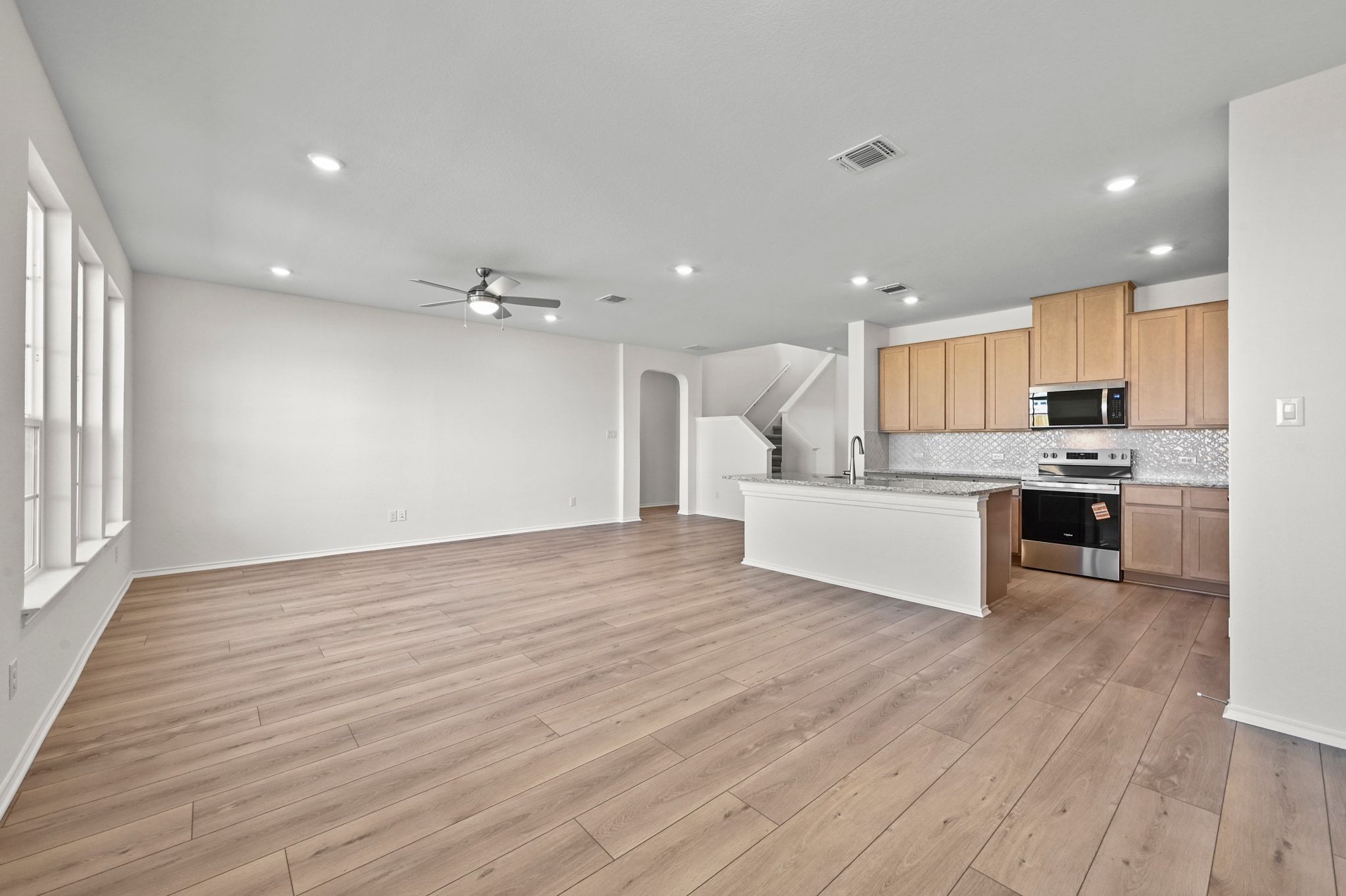 15004 Garrano Way Manor, TX 78653 - Photo 13 of 34 a view of kitchen with kitchen island wooden floors and stainless steel appliances