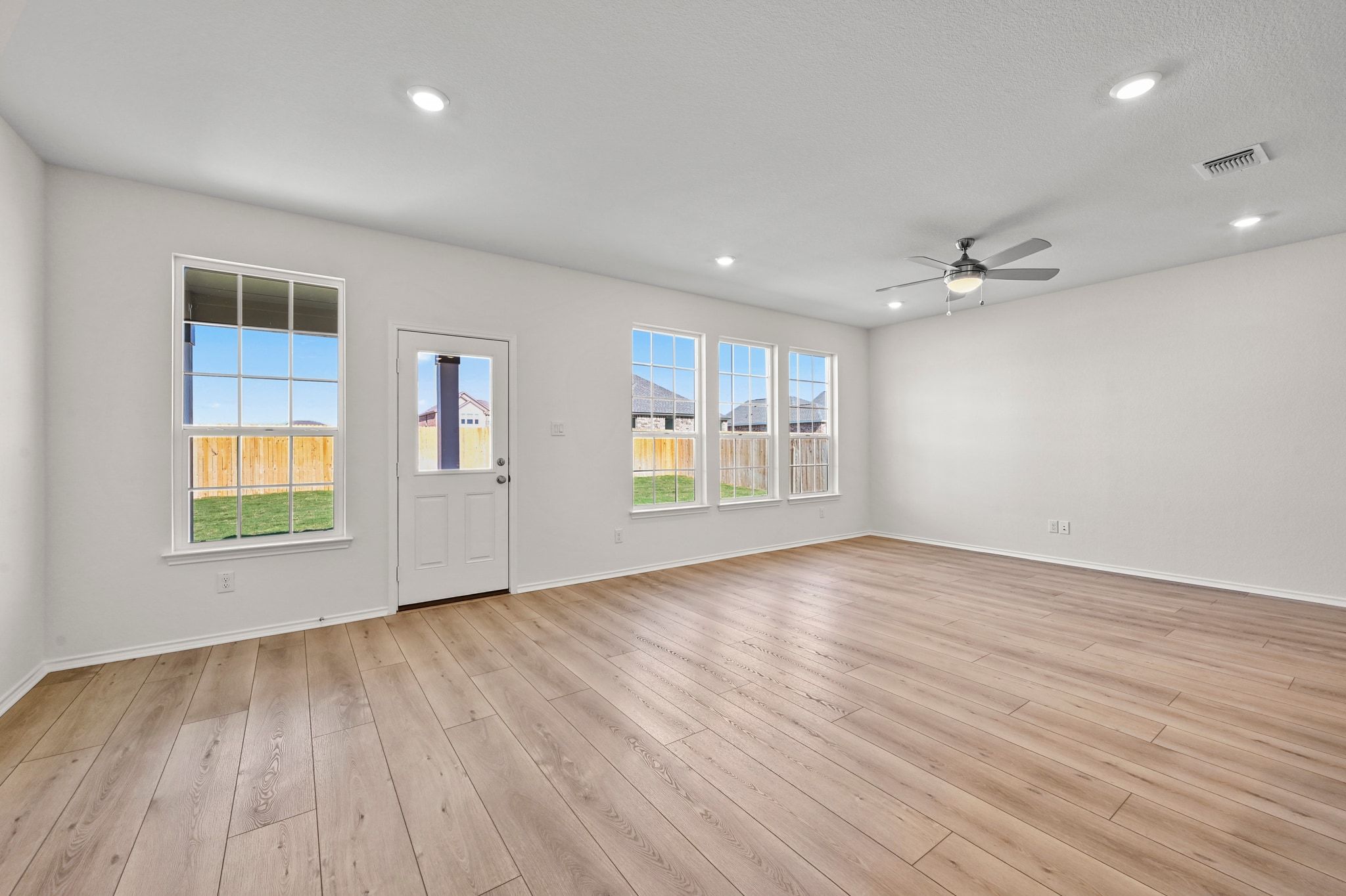 15004 Garrano Way Manor, TX 78653 - Photo 14 of 34 a view of an empty room with a window and wooden floor